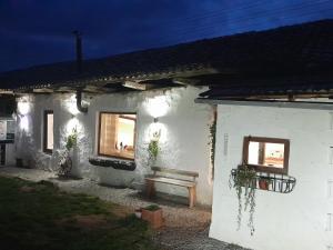 un bâtiment blanc avec un banc devant lui dans l'établissement Serendipity Cottage Palamartsa, à Palamarza