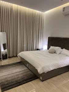 1 dormitorio con 1 cama grande y cortinas en شقه فلاتس الماجدية, en Riad