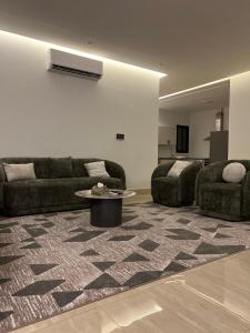Sala de estar con 2 sofás y mesa en شقه فلاتس الماجدية, en Riad