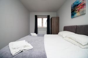 una camera da letto con un letto e asciugamani bianchi di K Suites - Carnival Court a Bridgwater