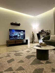 sala de estar con sofá y TV de pantalla plana en شقه فلاتس الماجدية, en Riad