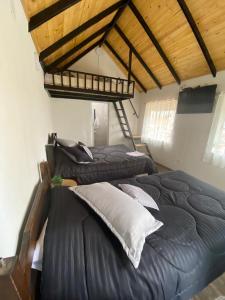 1 dormitorio con 2 camas y 1 loft en Hospedaje - Cabañas villa rosita, en Monguí