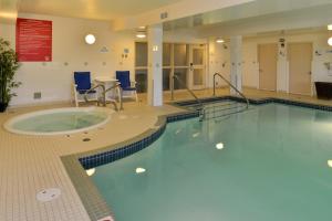 a swimming pool in a large room with a table and chairs at Holiday Inn Express Edmonton North, an IHG Hotel in Edmonton