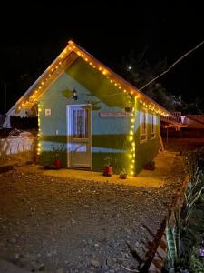 una pequeña casa con luces encendidas por la noche en Hospedaje - Cabañas villa rosita, en Monguí