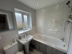 a bathroom with a sink and a tub and a toilet at Spacious House To Accommodate 6 in Willaston