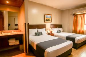 a hotel room with two beds and a bathroom at Epiqus Hotel in Lima