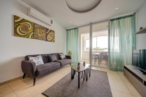 sala de estar con sofá y mesa en Exceptional Tigne Seafront Apartments by Shortletsmalta en Sliema