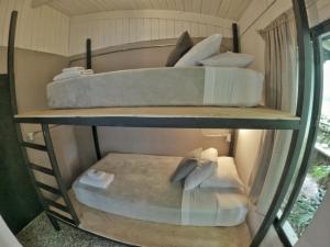two bunk beds in a room with a window at OutBox Inn in Monteverde Costa Rica