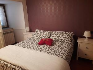1 dormitorio con 1 cama con 2 almohadas rojas en La casa del largo del rosso, en Pozzuoli