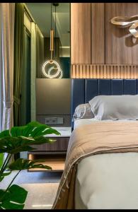 Gold Coast Apartemen PIK by Dluxx في جاكرتا: غرفة نوم مع سرير وزرع الفخار
