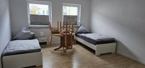 a room with two beds and a table and chairs at SES12 1-OG rechts Monteurwohnung in Wolfsburgs Zentrum in Wolfsburg