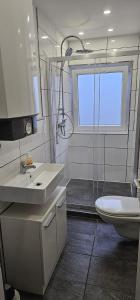 ein Bad mit einem Waschbecken, einem WC und einem Fenster in der Unterkunft SES12 1-OG rechts Monteurwohnung in Wolfsburgs Zentrum in Wolfsburg