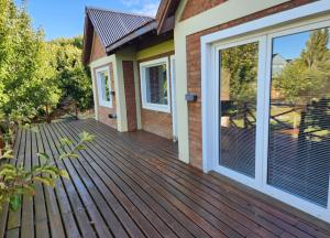 a wooden deck with sliding glass doors on a house at Cabañas La Chacra in El Calafate