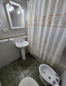 y baño con lavamanos y cortina de ducha. en Cabañas La Chacra en El Calafate