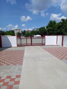 a walkway with a red fence and a brick sidewalk at White&Red Apartments in Timişoara