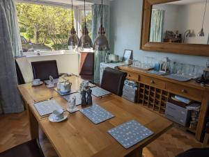 a kitchen with a wooden table with chairs and a sink at Little Barham B&B 