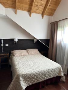 a bedroom with a bed and a staircase at Meulen Hosteria y Apart in El Calafate