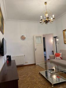 - un salon avec un canapé et un lustre dans l'établissement Apartamento Oporto, à Madrid