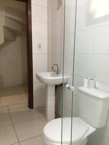 a bathroom with a toilet and a sink at Pousada Caminhos Do Mar in Imbituba