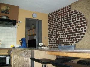 una cocina con una pared de ladrillo junto a un mostrador en Boskanthuisje en Kluisbergen