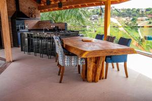 - une table et des chaises en bois dans la cuisine dans l'établissement Recanto Gabi Mafê., à Igaratá