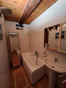 y baño con bañera y lavamanos. en La casa nell'airetta, en Balme