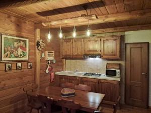 uma cozinha com armários de madeira e uma mesa de madeira em La casa nell'airetta em Balme