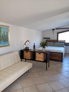 a living room with a couch and a bed at 26 km da Roma Monolocale ben collegato A.C. wifi in Rignano Flaminio