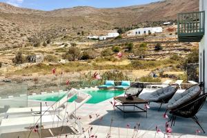 a patio with a pool with chairs and a table at Dream Villas Paros 1 ολόκληρος χώρος με πισίνα in Parikia