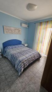 een slaapkamer met een bed met een blauwe muur bij Azienda Agricola Gentile - la casa degli ulivi in Vieste