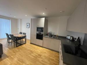 eine Küche und ein Esszimmer mit einem Tisch und Stühlen in der Unterkunft Lovely 2 Bedroom Apartment London in Woolwich