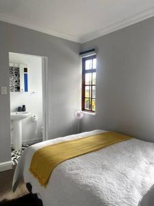 Milner Cottage: Digital Nomad Oasis في كيب تاون: غرفة نوم بيضاء مع سرير ومغسلة