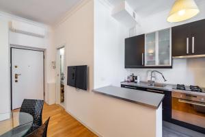 una cucina con elettrodomestici in bianco e nero e un tavolo di [Navigli-Centro] Comfort suite con WiFi a Milano