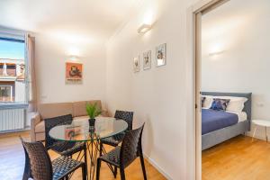 un soggiorno con tavolo, sedie e letto di [Navigli-Centro] Comfort suite con WiFi a Milano