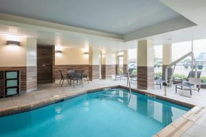a swimming pool with a patio and a dining area with chairs at Fairfield Inn & Suites by Marriott Chillicothe in Chillicothe