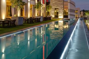a pool with tables and chairs next to a building at Protea Hotel Fire & Ice! by Marriott Pretoria Menlyn in Pretoria