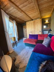 sala de estar con sofá rojo y azul en On the pistes of Sauze, en Sauze dʼOulx