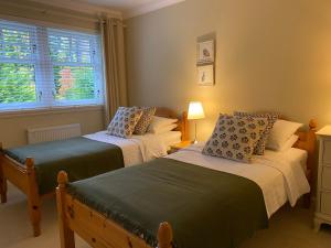 1 Schlafzimmer mit 2 Betten und einem Fenster in der Unterkunft Westwood Cottage in Aboyne