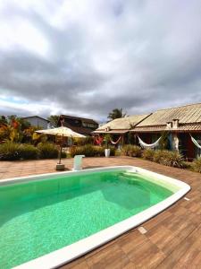 a swimming pool in front of a house at Noah Rosa Chalés in Praia do Rosa +11 photos