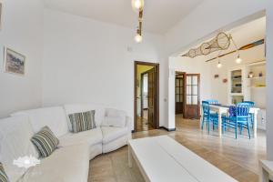 ein Wohnzimmer mit einem weißen Sofa und einem Tisch in der Unterkunft ALBA E TRAMONTO in Pieve Ligure