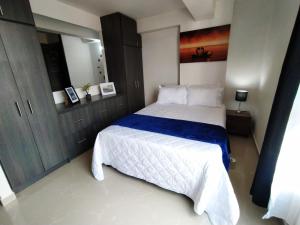 1 dormitorio con 1 cama con manta azul y blanca en Hermoso loft en medellin en Medellín