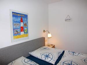 a bedroom with a bed and a picture of a lighthouse at Apartment Raum in Fehmarn Orth in Orth