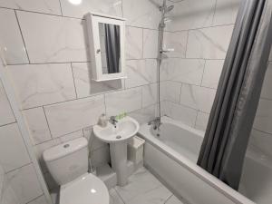 a bathroom with a toilet and a sink and a bath tub at K Suites - Harrogate Terrace in Bradford