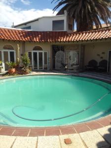 a large blue swimming pool in front of a house at Blue Oasis Apartments in Benoni