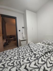a bedroom with a bed with a black and white comforter at SKYLUX apartments 7 in Jahorina