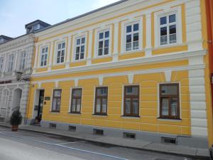 a yellow building with windows on a street at Frühstückspension Barbara in Pöchlarn