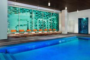 a pool with orange chairs next to a building at Aloft Boston Seaport District in Boston