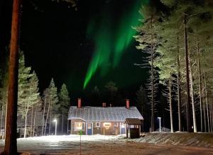a house with the aurora dancing in the sky at Levinlento in Levi