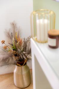 a vase with feathers and a candle on a table at Korte Apartment 2 in Arta