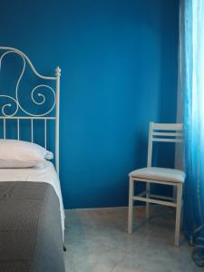 1 dormitorio azul con 1 cama y 1 silla en La Darsena Fiumicino, en Fiumicino